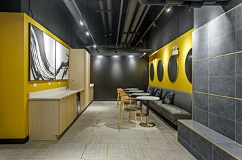 a room with a yellow and black wall and a table with chairs and a sink